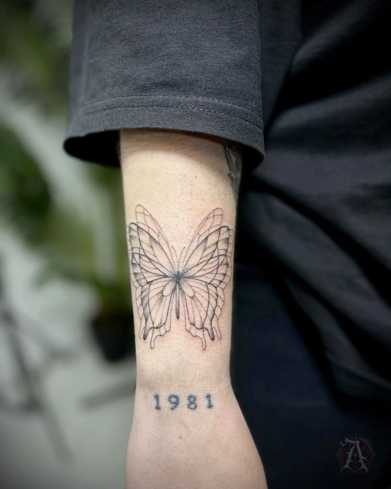 Tatuaje de mariposa y año en la muñeca, fine line en negro y gris
