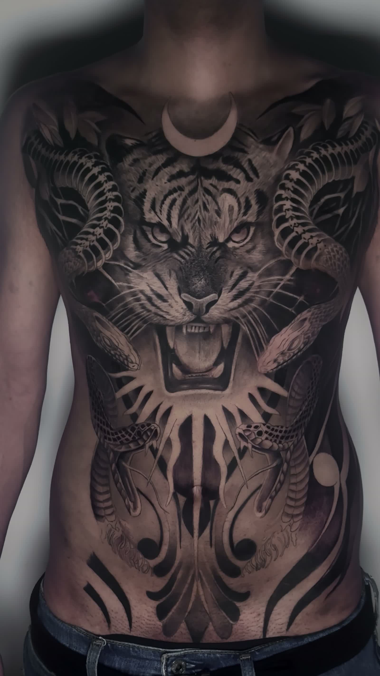 Tatuaje de un tigre y un dragón que cubre el torso, realismo en negro y gris